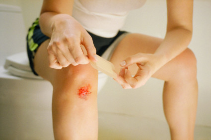 Bandaging a Scraped Knee --- Image by © Cat Gwynn/CORBIS